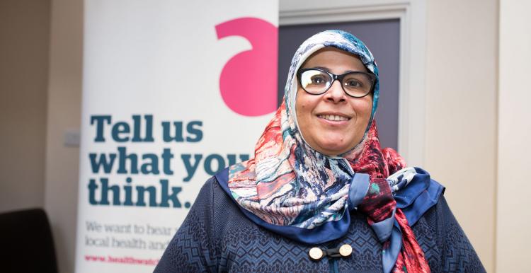 Volunteer standing in front of a Healthwatch banner