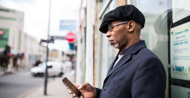 man holding a phone outside a building