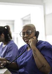 Receptionist staff at computer taking a telephone call