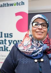 Volunteer standing in front of a Healthwatch banner